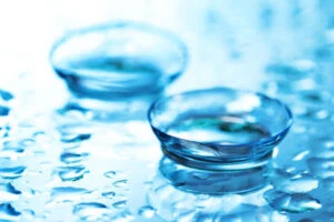 12980040 contact lens with drops on blue background